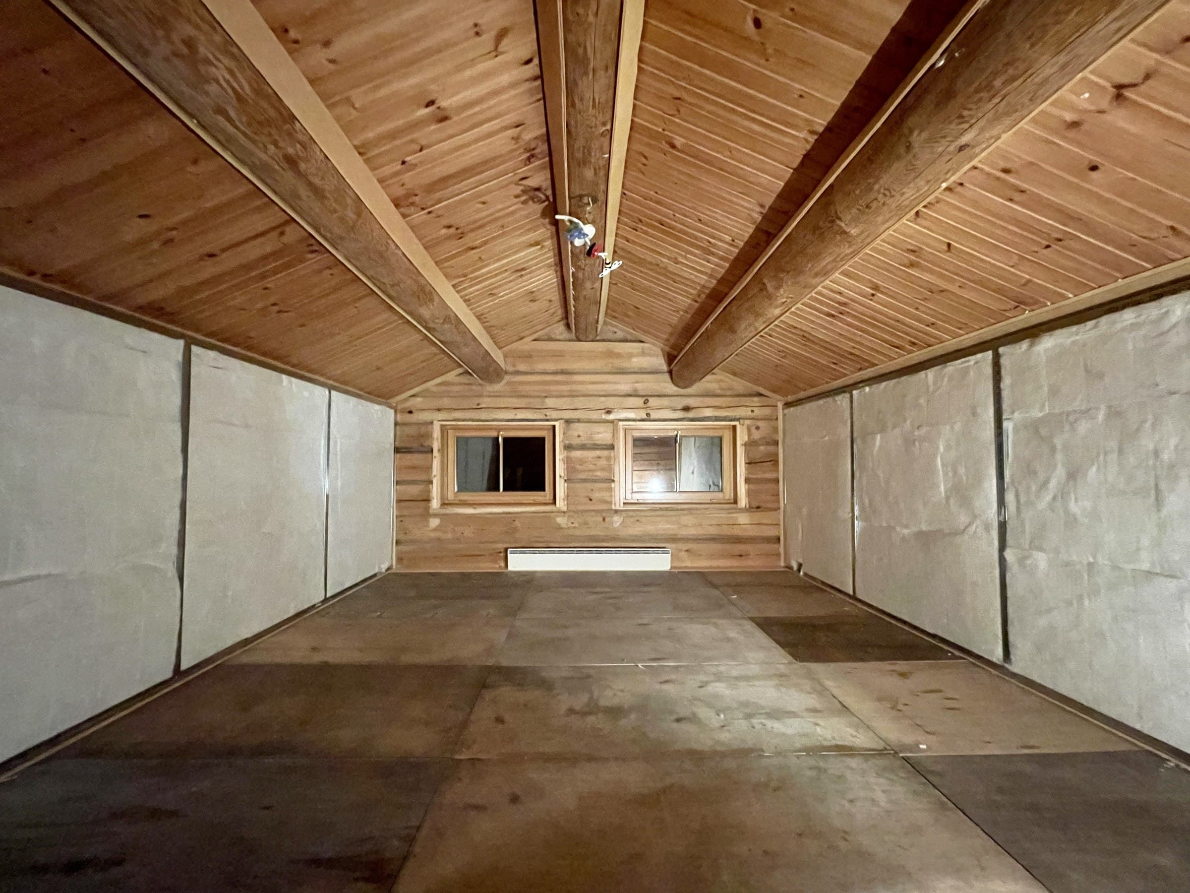 Side walls half paneled, back wall still bare log